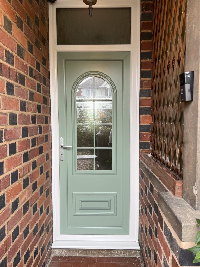 Chartwell green uPVC front door showing decorative glazing and white frame