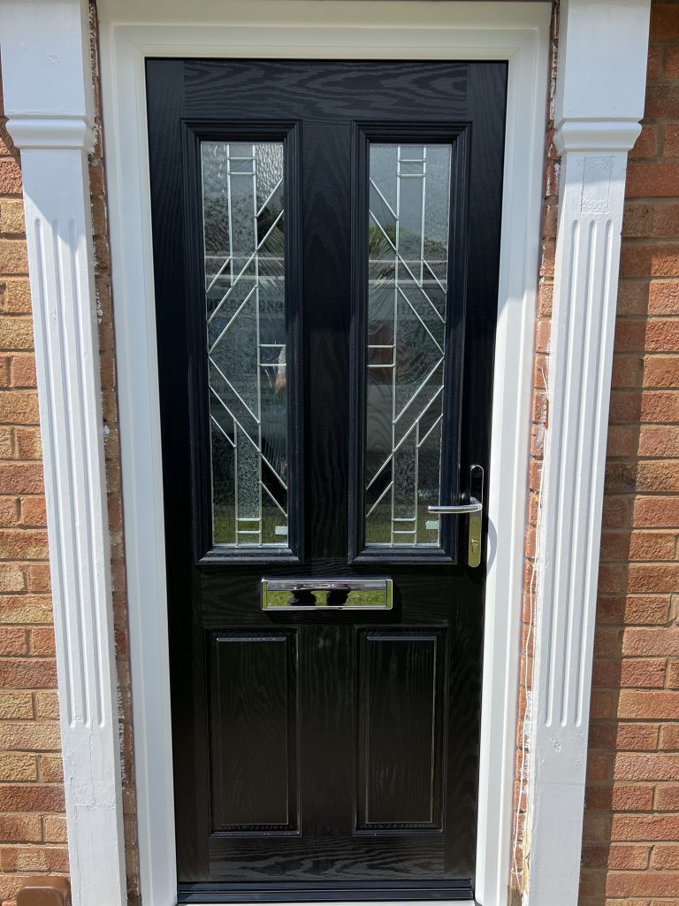 Black composite front door with decorative glazing installed in Perton