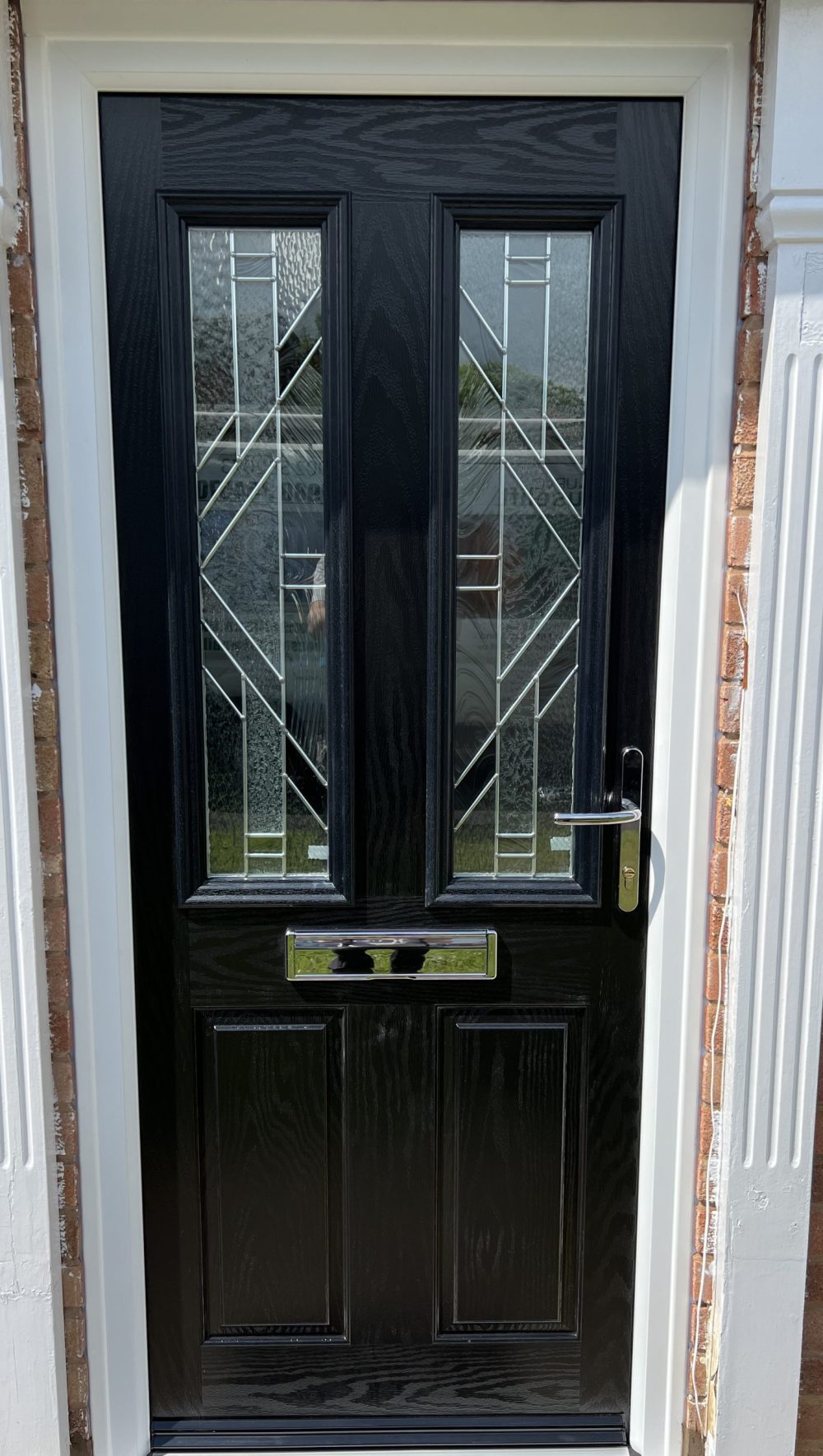 Black composite front door with decorative glazed panels professionally installed by uPVC Houselift in Perton